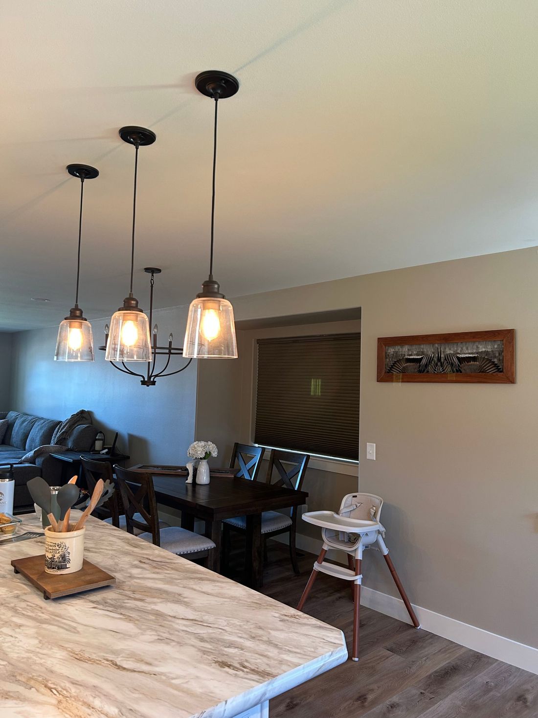 A pintail flying mount hanging on a dining room wall, seen past a kitchen island and pendant lights